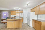 This spacious kitchen features light oak cabinetry and a convenient island with a breakfast bar.
