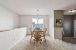 Enjoy meals in this charming dining area, featuring a classic wooden table and chairs set under a stylish pendant light.