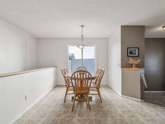 Enjoy meals in this charming dining area, featuring a classic wooden table and chairs set under a stylish pendant light.
