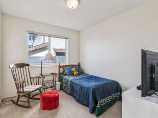 Discover this charming bedroom featuring a comfortable single bed adorned with a playful teddy bear and a cozy blue comforter.