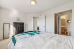 Discover comfort and convenience in this inviting bedroom, featuring a plush bed adorned with a vibrant quilt.