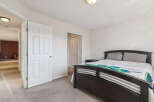Step into this inviting bedroom featuring a comfortable queen-sized bed adorned with a vibrant, patterned comforter.