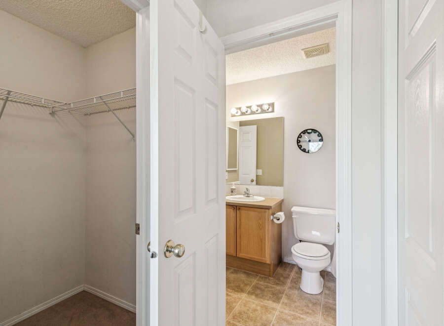 Discover a functional layout with a spacious walk-in closet featuring wire shelving, perfect for organization.