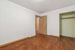 Discover this charming bedroom featuring a spacious layout and warm, inviting wood-look flooring.