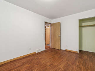 Discover this charming bedroom featuring a spacious layout and warm, inviting wood-look flooring.