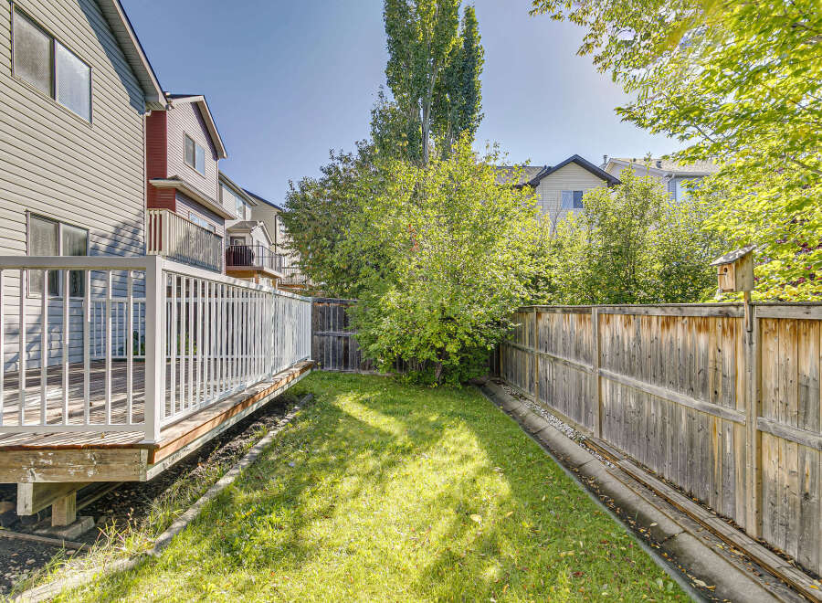 Enjoy outdoor living in this spacious backyard, complete with a large wooden deck perfect for entertaining.