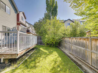 Enjoy outdoor living in this spacious backyard, complete with a large wooden deck perfect for entertaining.