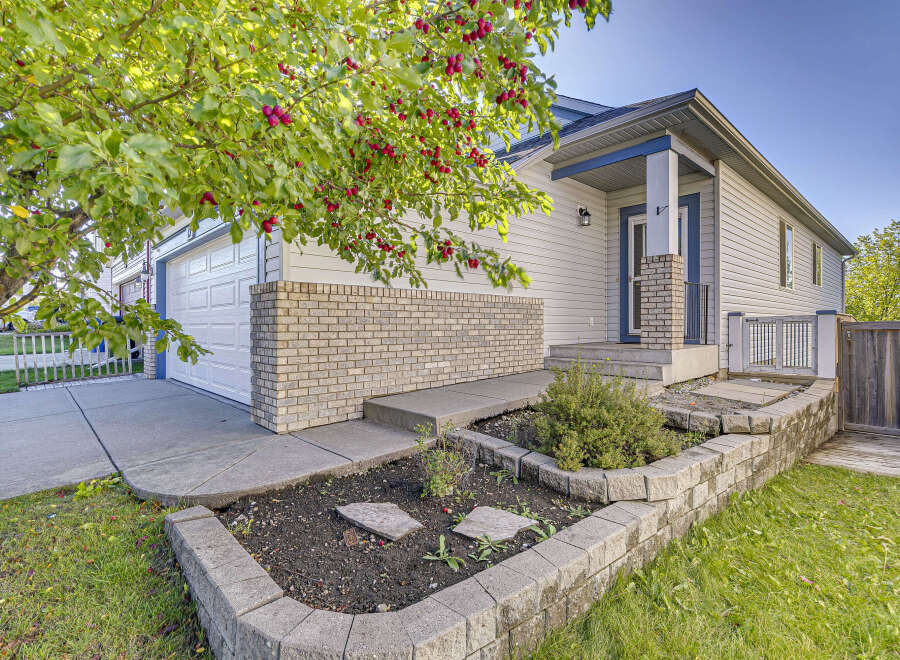 Charming single-family home featuring a welcoming front entrance with a covered porch and a two-car garage.