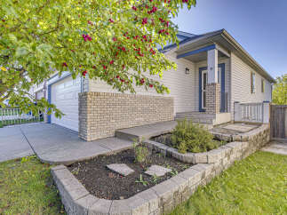 Charming single-family home featuring a welcoming front entrance with a covered porch and a two-car garage.