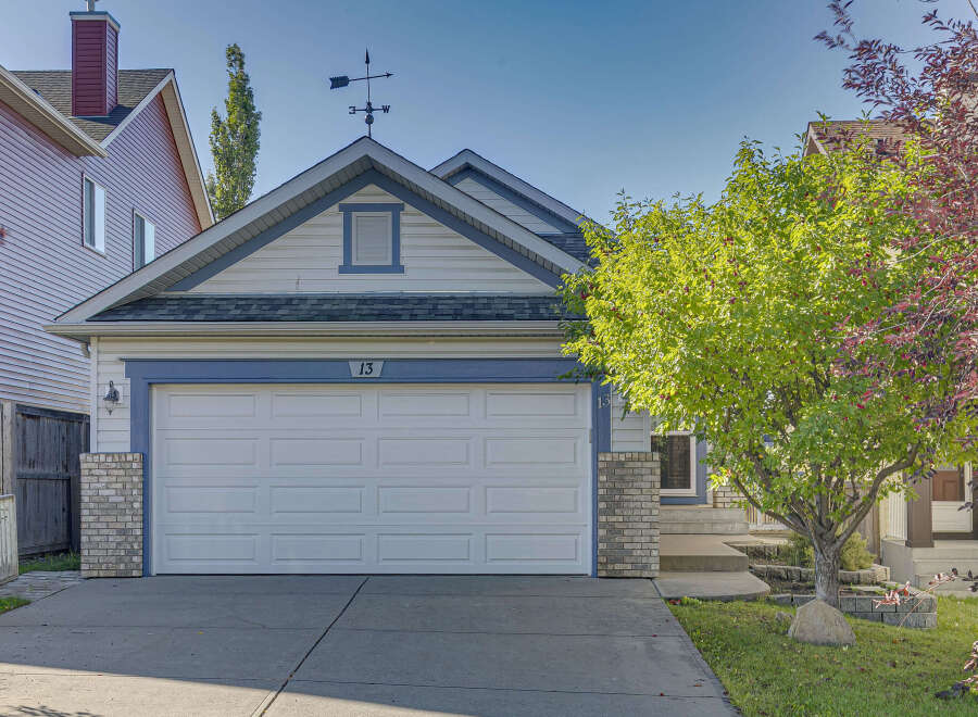 Charming single-family home featuring a classic white garage door with a decorative number '13' above.