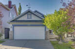 Charming single-family home featuring a classic white garage door with a decorative number '13' above.