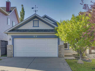 Charming single-family home featuring a classic white garage door with a decorative number '13' above.
