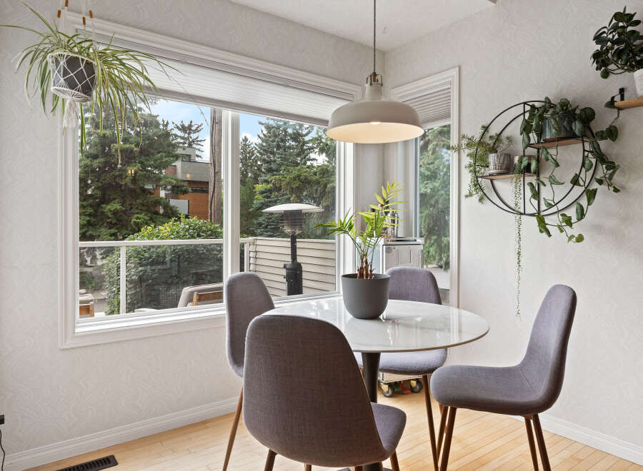 Enjoy your morning coffee in this bright and airy dining nook, featuring a stylish round table and comfortable seating.