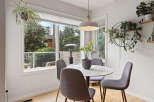 Enjoy your morning coffee in this bright and airy dining nook, featuring a stylish round table and comfortable seating.