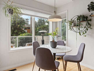 Enjoy your morning coffee in this bright and airy dining nook, featuring a stylish round table and comfortable seating.