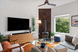Experience modern living in this stylish living room, featuring a sleek entertainment center and a cozy wood-burning stove.
