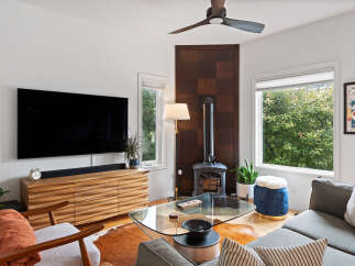 Experience modern living in this stylish living room, featuring a sleek entertainment center and a cozy wood-burning stove.
