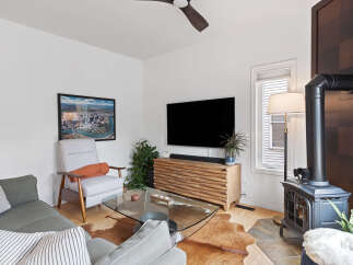 Experience modern living in this stylish living room, featuring a sleek entertainment center and a cozy armchair perfect for relaxation.