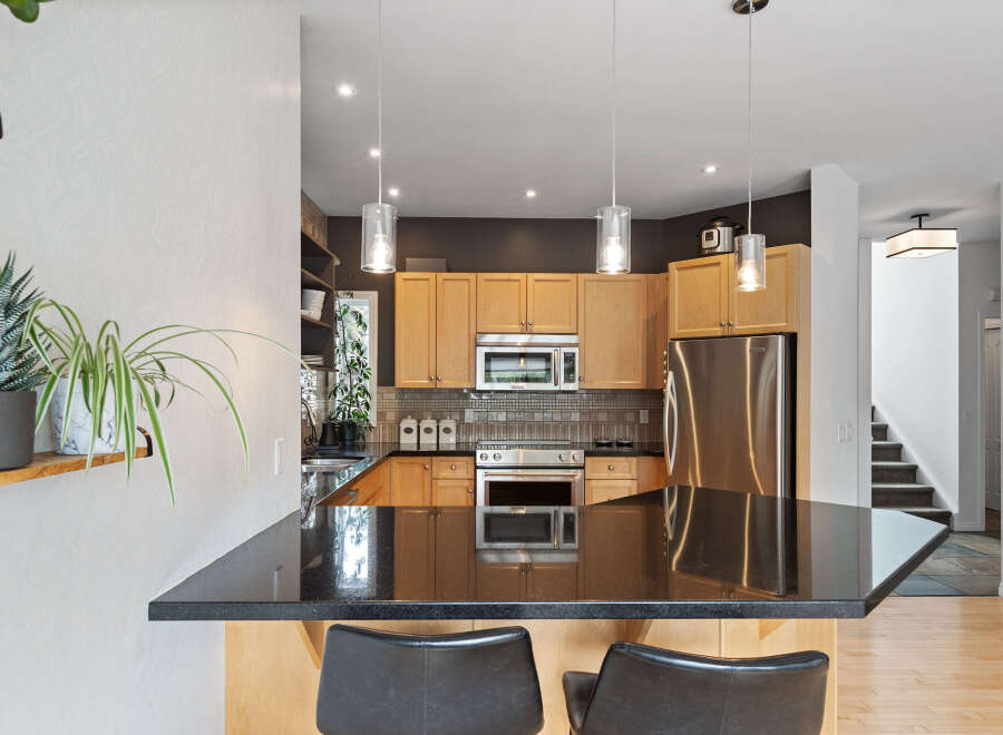 Discover this stunning kitchen featuring sleek granite countertops and warm wood cabinetry, perfect for culinary enthusiasts.