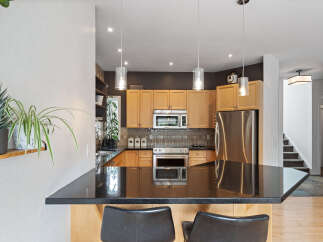 Discover this stunning kitchen featuring sleek granite countertops and warm wood cabinetry, perfect for culinary enthusiasts.