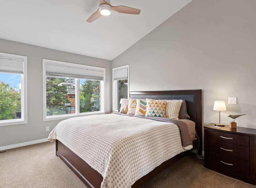 Experience comfort and style in this beautifully appointed bedroom, featuring a spacious king-size bed with a dark wood headboard and plush decorative pillows.