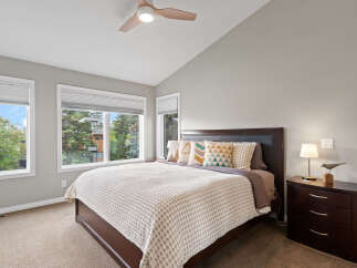 Experience comfort and style in this beautifully appointed bedroom, featuring a spacious king-size bed with a dark wood headboard and plush decorative pillows.
