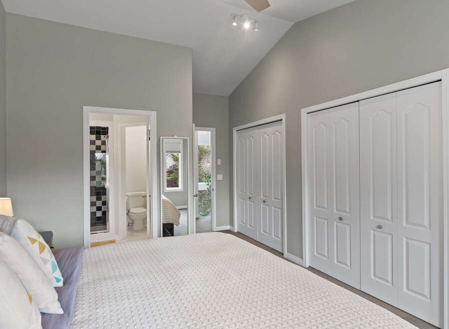 Discover comfort and style in this spacious bedroom, featuring a vaulted ceiling and ample natural light.