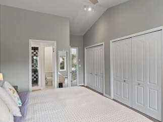 Discover comfort and style in this spacious bedroom, featuring a vaulted ceiling and ample natural light.
