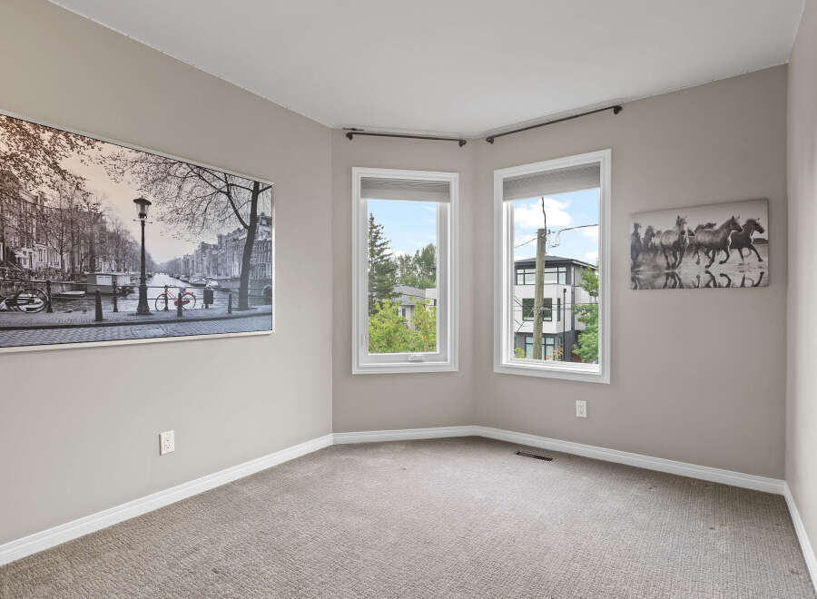 This spacious room features a large black and white cityscape artwork on the left wall and a dynamic horse-themed artwork on the right.