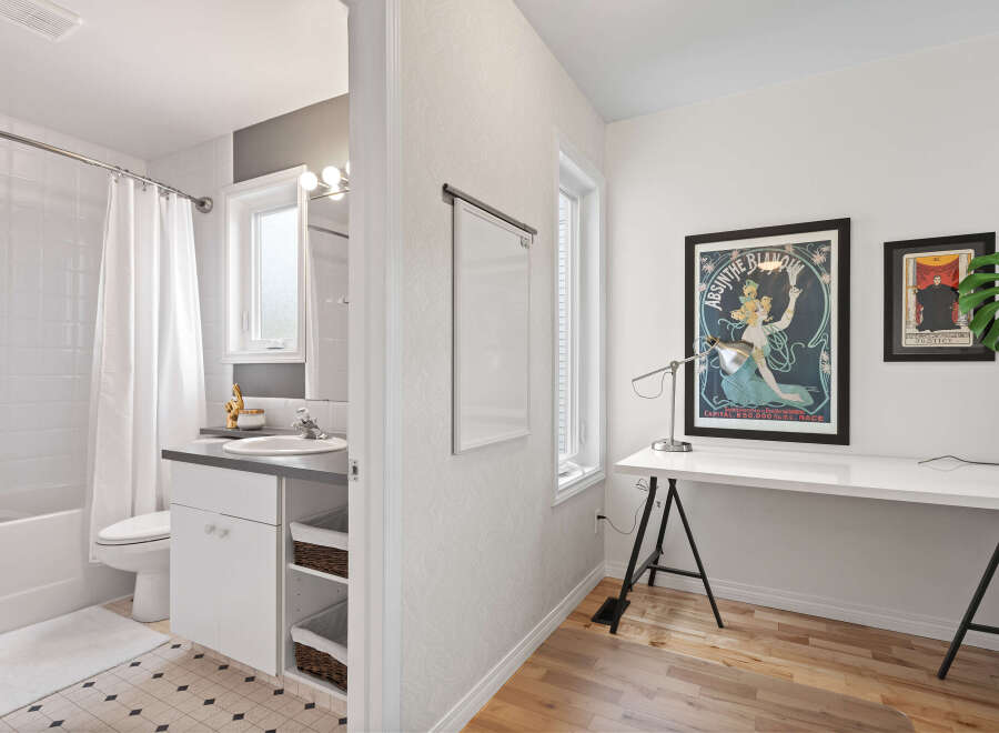 Discover a versatile space with a modern bathroom featuring a bathtub, toilet, and vanity, complemented by a bright workspace.
