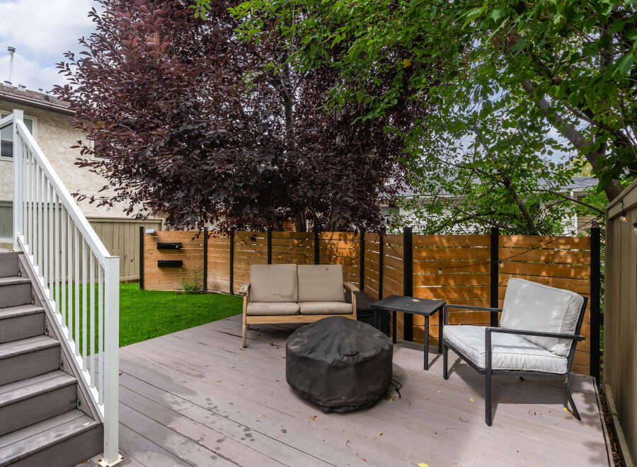 Enjoy outdoor living on this spacious deck featuring comfortable seating and a fire pit, perfect for gatherings.