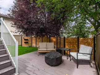 Enjoy outdoor living on this spacious deck featuring comfortable seating and a fire pit, perfect for gatherings.