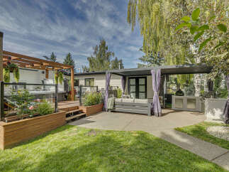 Experience ultimate outdoor living with this stunning backyard oasis, featuring a luxurious hot tub on a spacious wooden deck.