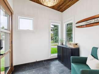 Step into this inviting entryway featuring a stunning wood-paneled vaulted ceiling and a modern crystal chandelier.
