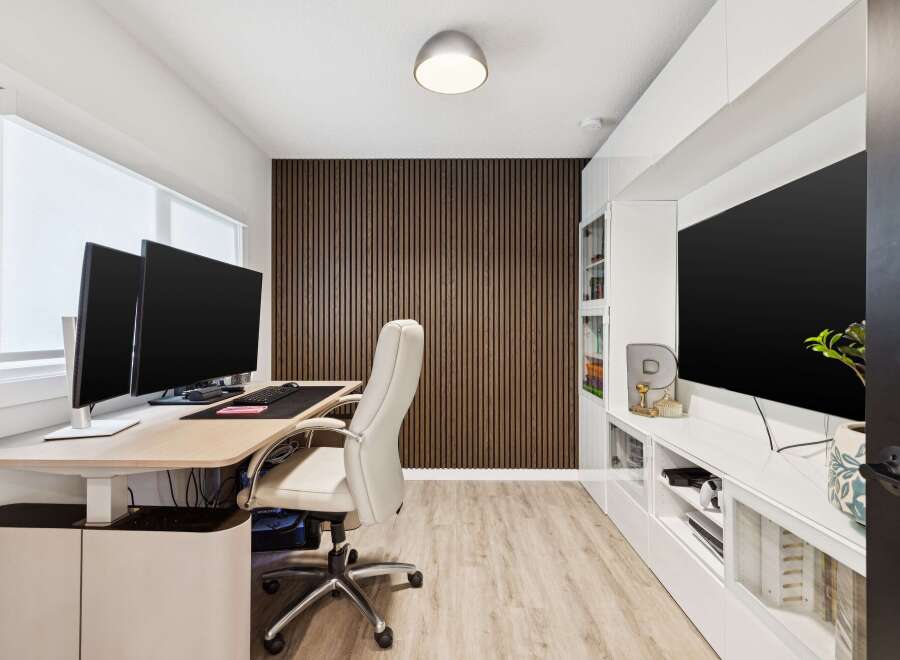 This modern home office features a sleek, height-adjustable desk with dual monitors, perfect for productivity.