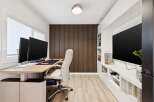 This modern home office features a sleek, height-adjustable desk with dual monitors, perfect for productivity.