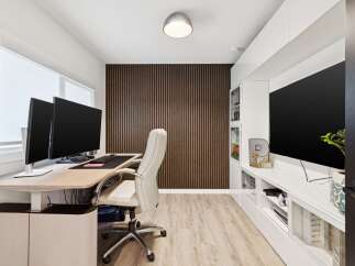 This modern home office features a sleek, height-adjustable desk with dual monitors, perfect for productivity.