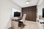 This modern home office features a sleek, height-adjustable desk with dual monitors, perfect for productivity.
