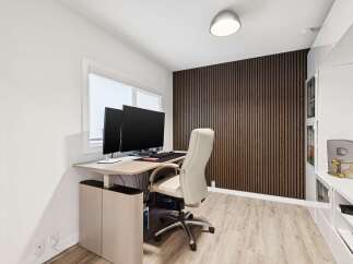 This modern home office features a sleek, height-adjustable desk with dual monitors, perfect for productivity.