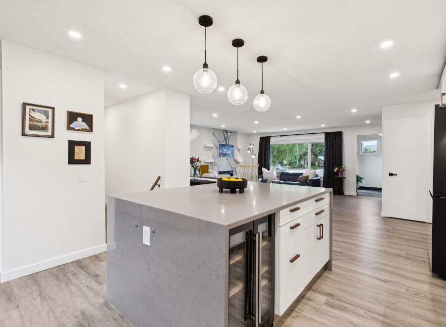 Experience modern living in this stunning open-concept kitchen, featuring a sleek island with a built-in wine fridge and ample counter space.