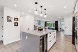 Experience modern living in this stunning open-concept kitchen, featuring a sleek island with a built-in wine fridge and ample counter space.