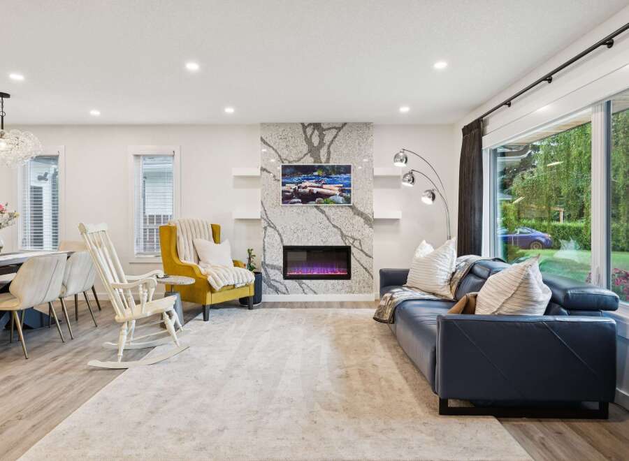 Experience modern living in this spacious open-concept living area, featuring a stunning granite-clad fireplace as the centerpiece.