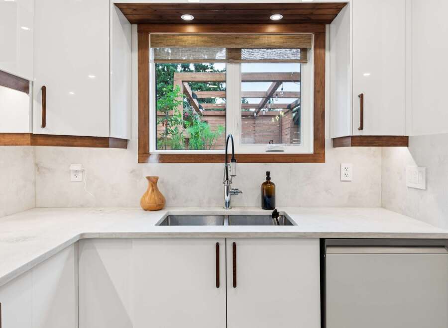 Experience modern living in this stunning kitchen, featuring sleek white cabinetry complemented by warm wood accents.