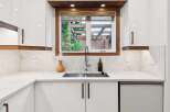 Experience modern living in this stunning kitchen, featuring sleek white cabinetry complemented by warm wood accents.