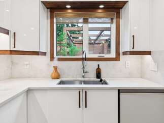 Experience modern living in this stunning kitchen, featuring sleek white cabinetry complemented by warm wood accents.