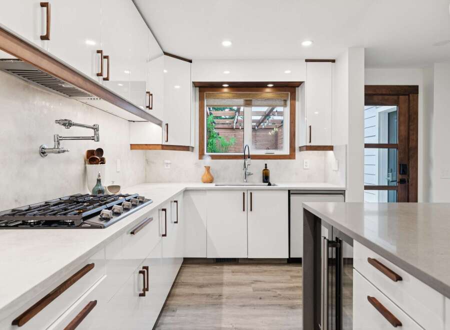 Experience modern luxury in this stunning kitchen, featuring sleek white cabinetry complemented by warm wood accents.