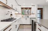 Experience modern luxury in this stunning kitchen, featuring sleek white cabinetry complemented by warm wood accents.