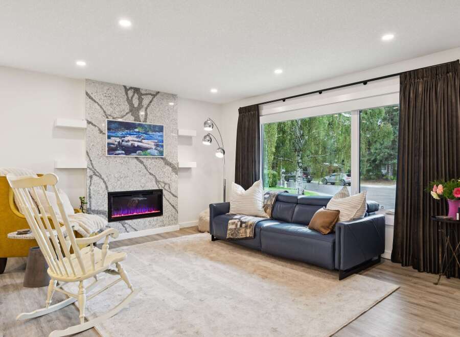 Experience modern living in this stunning living room, featuring a sleek electric fireplace set against a dramatic stone accent wall.