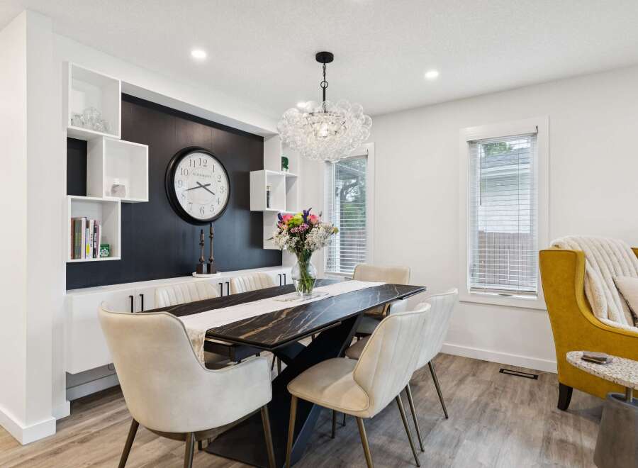 This elegant dining room features a sleek black marble-top dining table with modern chairs, perfect for hosting gatherings.