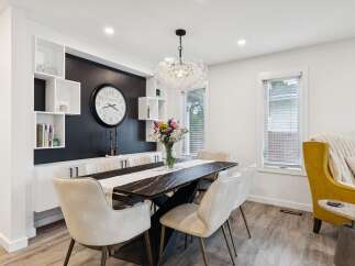 This elegant dining room features a sleek black marble-top dining table with modern chairs, perfect for hosting gatherings.